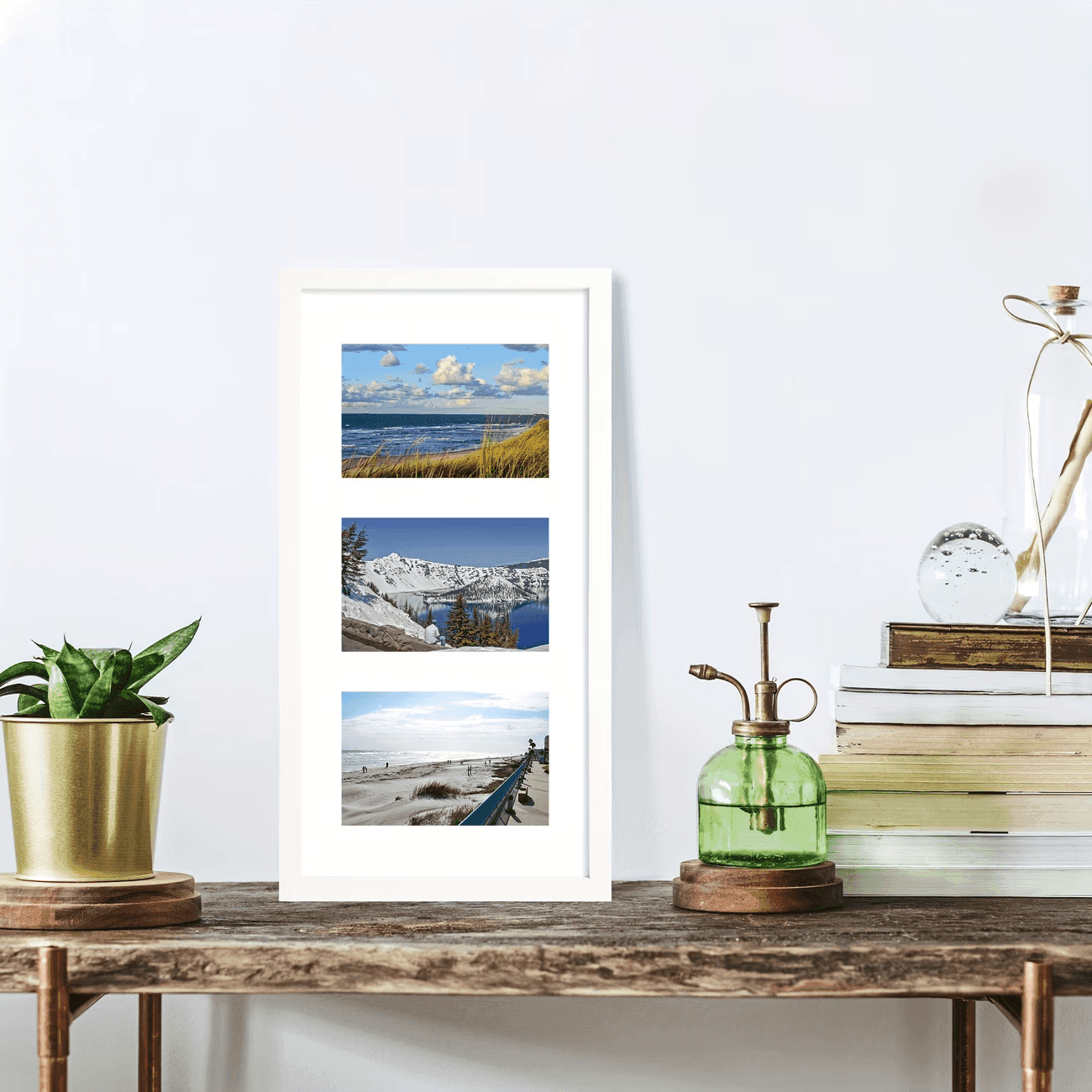 A white triple frame of beach and mountain photos on a wooden bench